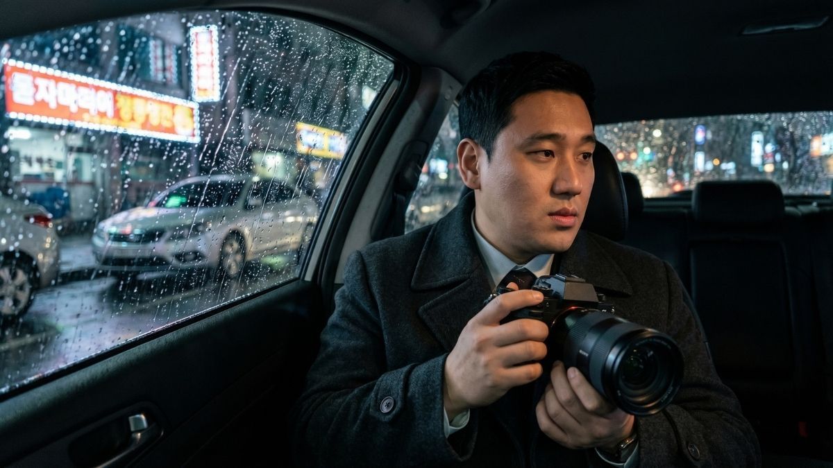 차량안에서 증거를 수집하기 위해 카메라를 들고 있는 고탐정